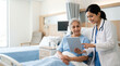 © Someone Cooked Here - professional indian female doctor assisting senior woman patient with tablet in modern hospital room for digital healthcare and patient support concept