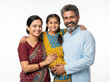 © Someone Cooked Here - middle aged indian rural family with young daughter posing together isolated on white background for family bonding and rural lifestyle concept