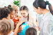 © chokniti - Back to school and education concept of group of schoolchild study globe in classroom with teacher, diverse pupil explore geography together