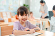 © chokniti - Back to school and education concept of young girl smiling in classroom at desk with notebook and pencil school girl child classroom student desk notebook pencil smile