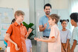 © chokniti - Back to school and education concept of diverse schoolchildren playing hand game with teacher in bright classroom, happy social interaction and teamwork