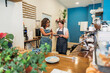 © PintoArt - Diverse women baristas collaborating discussing business using tablet