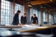 © Microstocke - Blurred Three colleagues collaborating on project at large wooden table in modern office