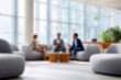 © Microstocke - Blurred Diverse Business Team Collaborating in Modern Office Lobby