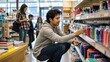 © ArtFocus Studio - Young man shopping for stationery and pens in a store during back to school season