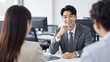 © Studicon - Smiling young asian businessman in a meeting with colleagues in the office