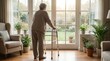 © RAAL - Elderly woman with walker looking out through a bright window at home
