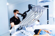 © Vadim - Selective focus on dental tools with dentist in background. Foreground view of dental equipment with a blurred dentist using a microscope in the background.