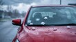 © Mariia - Red car damaged by hailstorm with cracked windshield and hailstones, illustrating severe weather damage, auto insurance claims and natural disaster impact