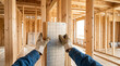 © Elenba - Worker installing foil faced insulation board in a wooden wall frame. Thermal barrier and moisture protection in house construction. Home building process