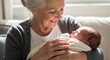 © Faridzal - Loving grandmother holding her sleeping newborn grandchild at home