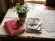 © Kashif - Vintage family photographs and a red 'Old Memories' book rest on a rustic wooden table by a sunlit window.