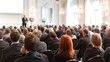 © jhani - Audience attentively listens to speaker at a business conference event.