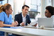 © Goran - Mid adult businessman having a meeting with group of doctors in hospital