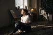 © Andrii Lysenko - Young curly woman artist drawing on notebook at art studio in Hard light, sunny