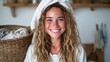 © svastix - A cheerful woman with curly hair, wearing a towel on her head, smiles brightly while holding a basket of freshly laundered clothes, embodying the essence of a happy home life.