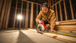 © Alex & M Studio - Skilled female carpenter in safety gear using electric circular saw to cut wooden planks on construction site of new residential house building professional joinery and wood work concept