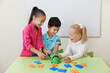 © Maria - Preschool children playing with alphabet letters on a desk