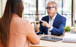 © David - Senior businessman mentoring young professional woman in office