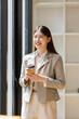 © David - Young asian businesswoman smiling holding coffee cup in office