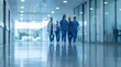 © Pixels Stock - Medical team walking down bright hospital corridor modern clinic hallway with reflective floor and ceiling lights showing doctors nurses in blue scrubs teamwork caring professionals unified approach.