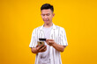 © Gatot - Young Asian Man Using Mobile Phone and Credit Card for Digital Payment or E-commerce Transaction