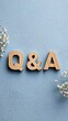 © Bela - Q&A wooden letters on a blue textured background with flowers