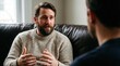 © AspctStyle - Bearded man explaining with hand gestures during a therapy session on a leather sofa. Mental health counseling, life coaching and professional consultation concept.