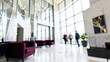 © Blurred Bokeh - Modern corporate lobby interior with people walking through large windows