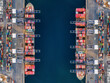 © moofushi - High aerial overhead view of a large container cargo ship terminal with two super cargo ships docked and unloading activity
