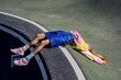 © Sunlight - Youthful woman reclining on a cement structure in a skatepark, donning vibrant and stylish urban attire