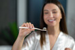 © zinkevych - Long-haired young woman brushing her teeth in the morning