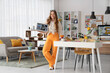 © Pixel-Shot - Female web designer with laptop in office