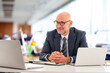 © gzorgz - Middle-aged professional businessman sitting at the office and using his laptop