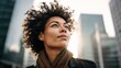 © Renderly - Confident woman looking up in a city setting with skyscrapers in the background