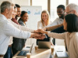 © ibrahim nuruz - A vibrant gathering of diverse business professionals demonstrates exceptional teamwork and strong unity stacking their hands in a symbolic gesture of collaborative strength and shared commitment towa