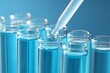 © New Africa - Dripping liquid sample into test tubes with pipette on blue background, closeup