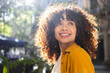 © ADDICTIVE STOCK - Smiling woman with curly hair enjoying outdoor lifestyle
