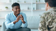 © Prostock-studio - Two men are engaged in a discussion in a simple indoor space. One man wears a blue shirt and speaks with hand gestures while the other listens attentively. Their conversation appears meaningful.