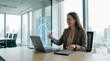 © Stitch - Smiling businesswoman sitting at her desk interacting with a glowing digital human hologram from her laptop