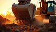© Vadym - Excavator bucket digs soil during golden hour sunset. Dirt flies from machine as operator works construction site. Heavy equipment power transforms earth.