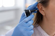 © New Africa - Hearing test. Doctor examining woman's ear with otoscope in clinic, closeup. Space for text