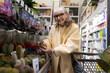 © Ivan Traimak - Senior woman shopping for succulents at a large retail garden center