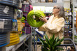 © Ivan Traimak - Senior woman shopping for a garden hose and plants in a large retail store