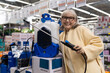 © Ivan Traimak - Senior woman at hardware store choosing a battery powered garden sprayer