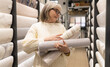 © Ivan Traimak - Senior woman is holding rolls of wallpaper, choosing materials for home renovation