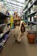 © Ivan Traimak - Woman shopping for flower pots and plant supplies, talking on her mobile phone
