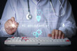 © Piya W. - Focused doctor uses modern telemedicine technology with an advanced ai assistant hologram projection above mechanical keyboard