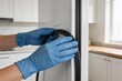 © Charles - Person wearing gloves handling refrigerator door seal