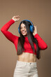 © Dulúapics - Happy woman dancing with headphones and enjoying the rhythm